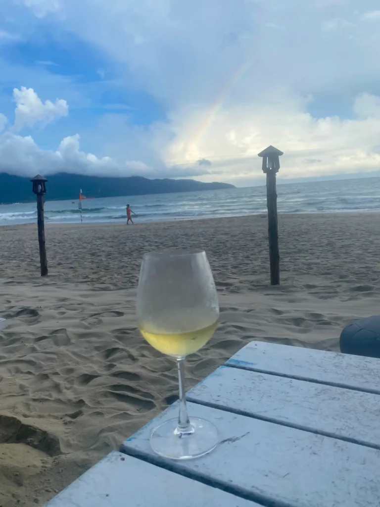 With a beautiful view of the beach and a lucky rainbow drinking wine during happy hours at an outdoor beach bar overlooking the beautiful Danang beach; this should help decide where to stay in Danang!