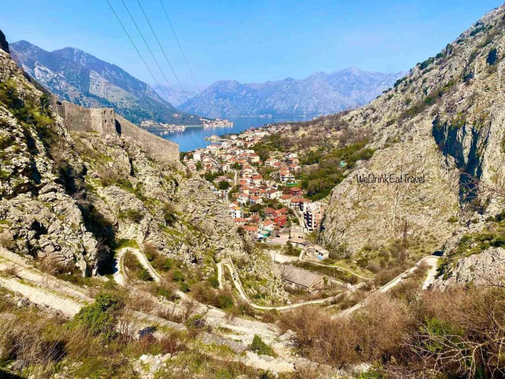 Scenic winding hiking path in Kotor, Montenegro with a bird's eye view of the town between a rocky mountain landscape, offering breathtaking views of the Bay of Kotor.