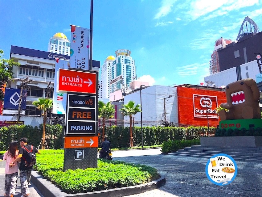 Signs for the popular SuperRich money exchange store in Bangkok with other shops and signs surrounding it.